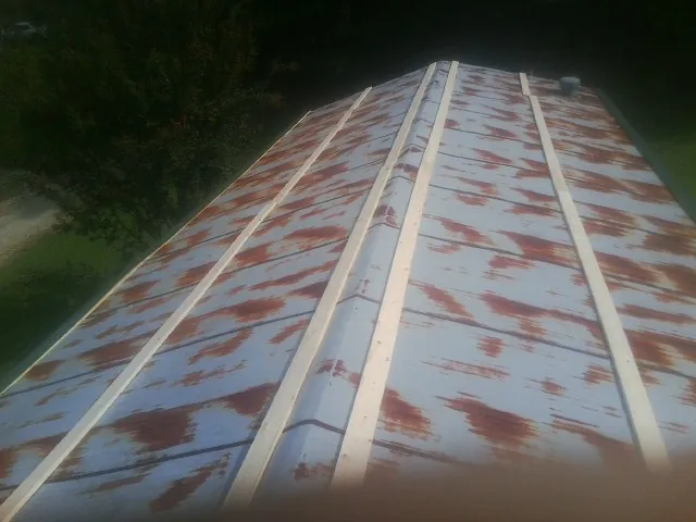 Rusted metal roof panels with new wood purlins before replacement — Storm Damage Roof Repair in Corinth by Roofing Brothers