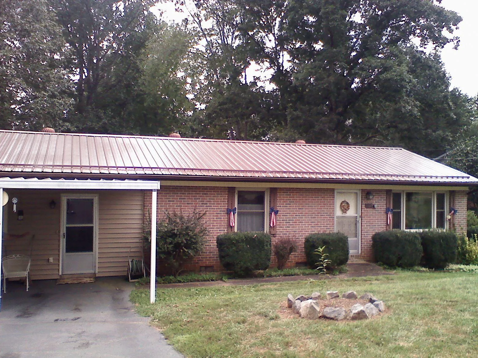 Bronze metal roof and carport on a brick ranch home — Roof Repair work by our crew in Corinth